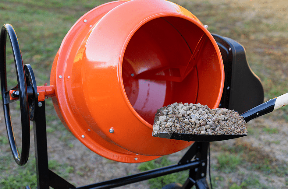 gravel been shovelled into cement mixer