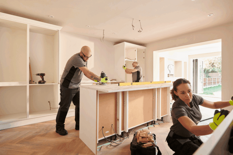 Two men and a women fitting new kitchen