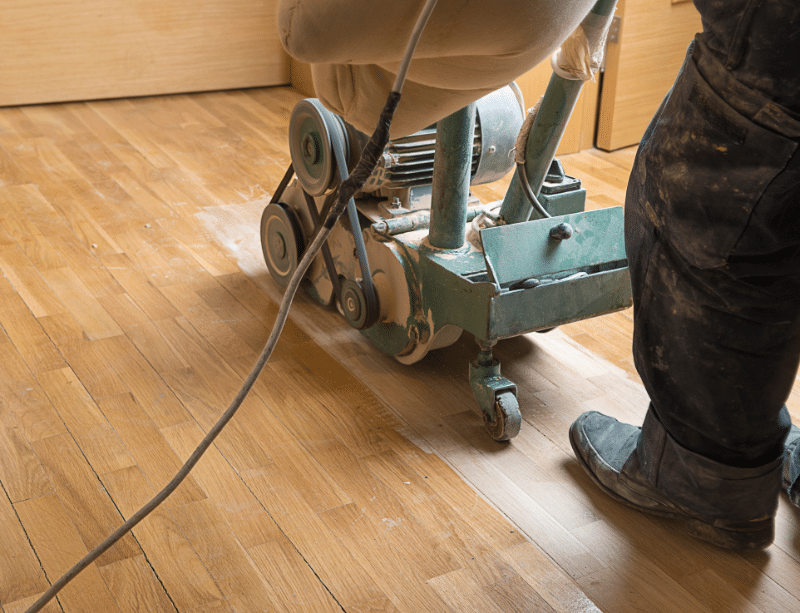 Industrial floor sander being pushed along