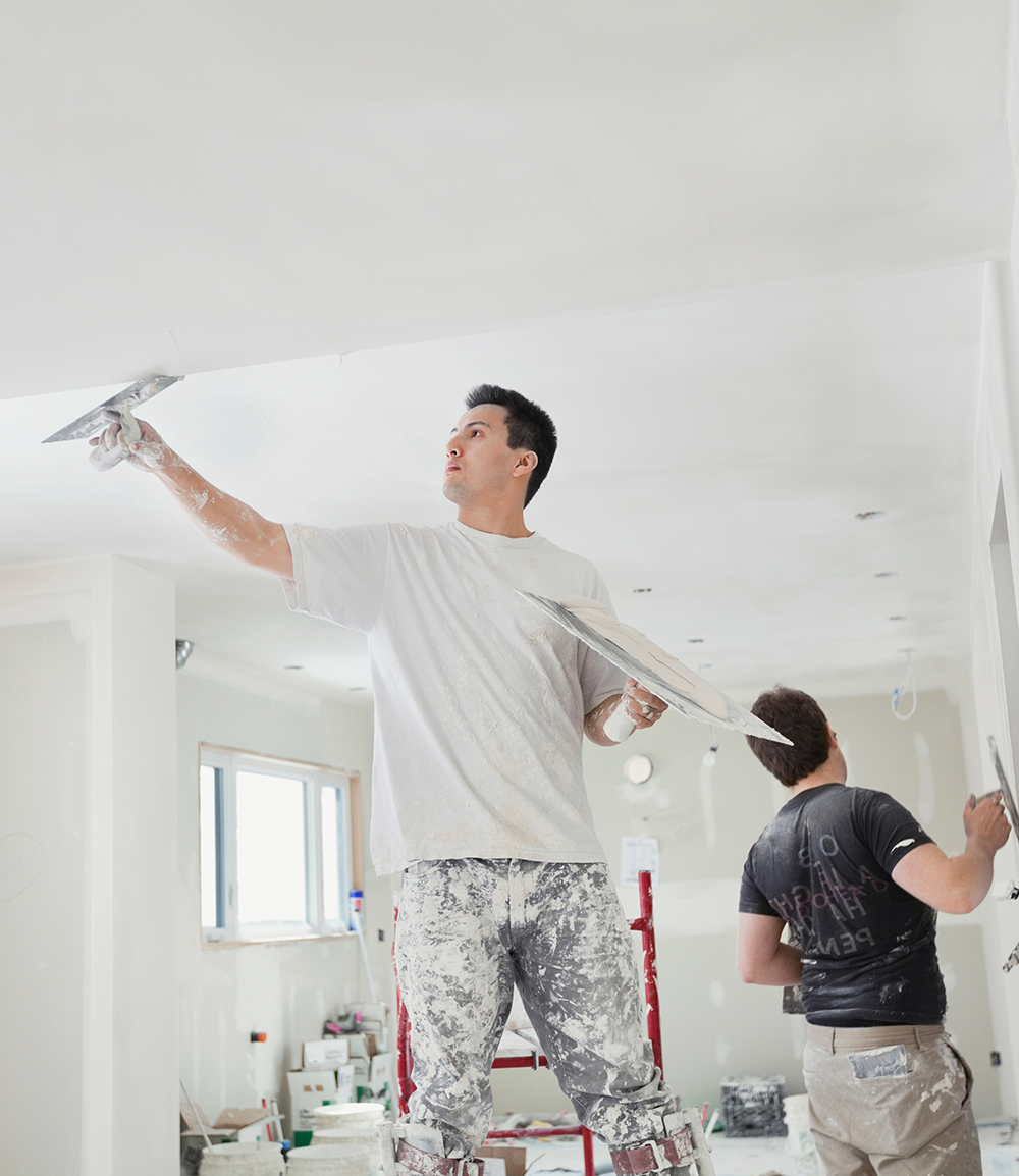 Two trades men plastering ceiling