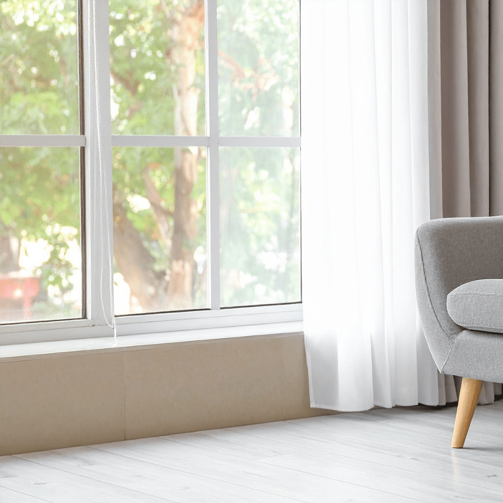 Modern white UPVC windows with slight traditional feel, grey armchair in corner